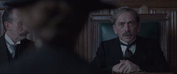 Movie still from “Suffragette” (2015), directed by Sarah Gavron – A man sitting in a chair in front of a window; Close Up shot, Over the shoulder angle