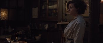 Movie still from “Suffragette” (2015), directed by Sarah Gavron – A woman standing in front of a mirror in a room; Medium shot, Over the shoulder angle