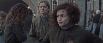 Movie still from “Suffragette” (2015), directed by Sarah Gavron – Two women in military uniforms are standing in front of a brick building; Close Up shot, Over the shoulder angle
