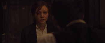 Movie still from “Suffragette” (2015), directed by Sarah Gavron – A young woman looking at a man in a suit in front of a mirror; Close Up shot, Over the shoulder angle