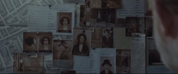 Movie still from “Suffragette” (2015), directed by Sarah Gavron – A bunch of old photos are hanging on a wall; Extreme Close Up shot, Overhead angle