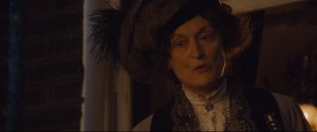 Movie still from “Suffragette” (2015), directed by Sarah Gavron – An older woman wearing a hat with a feather on it; Close Up shot, Over the shoulder angle