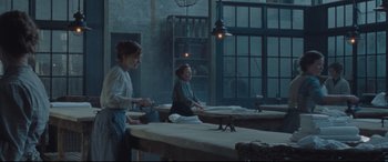 Movie still from “Suffragette” (2015), directed by Sarah Gavron – Two women standing at a table in front of a window; Wide shot, High angle