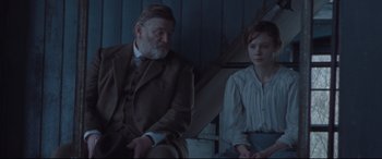 Movie still from “Suffragette” (2015), directed by Sarah Gavron – A man and a woman sitting next to each other; Medium shot, Over the shoulder angle