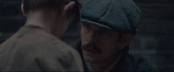 Movie still from “Suffragette” (2015), directed by Sarah Gavron – A person wearing a hat; Close Up shot, Over the shoulder angle