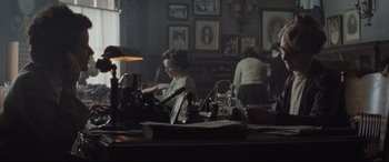 Movie still from “Suffragette” (2015), directed by Sarah Gavron – A woman sitting at a table in front of a window; Medium shot, Over the shoulder angle