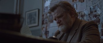 Movie still from “Suffragette” (2015), directed by Sarah Gavron – An older man with a beard is looking at his phone; Medium shot, Over the shoulder angle
