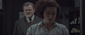 Movie still from “Suffragette” (2015), directed by Sarah Gavron – A man and a woman standing next to each other; Medium shot, Over the shoulder angle