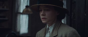 Movie still from “Suffragette” (2015), directed by Sarah Gavron – A young woman wearing a hat and a jacket; Close Up shot, Low angle