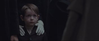 Movie still from “Suffragette” (2015), directed by Sarah Gavron – A young boy wearing gloves and a coat; Close Up shot, Over the shoulder angle
