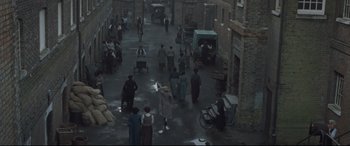 Movie still from “Suffragette” (2015), directed by Sarah Gavron – An overhead view of people walking down a street; Extreme Wide shot, High angle