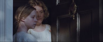 Movie still from “Suffragette” (2015), directed by Sarah Gavron – Two young girls standing next to each other in front of a door; Close Up shot, Over the shoulder angle