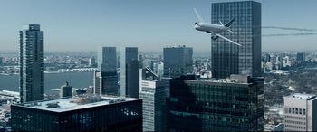 Movie still from “Sully” (2016), directed by Clint Eastwood – An airplane is flying over a large city with skyscrapers in the background; Extreme Wide shot, Low angle