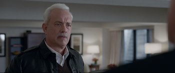 Movie still from “Sully” (2016), directed by Clint Eastwood – An older man with a white beard is looking at the camera; Close Up shot, Over the shoulder angle