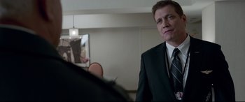 Movie still from “Sully” (2016), directed by Clint Eastwood – A man wearing a suit and tie in front of a mirror; Close Up shot, Over the shoulder angle