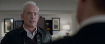 Movie still from “Sully” (2016), directed by Clint Eastwood – An older man in a leather jacket is looking at the camera; Close Up shot, Over the shoulder angle