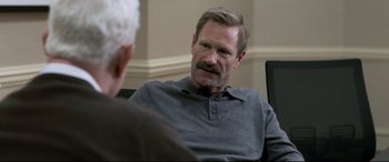Movie still from “Sully” (2016), directed by Clint Eastwood – A man sitting in front of another man in front of a wall; Close Up shot, Over the shoulder angle