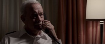 Movie still from “Sully” (2016), directed by Clint Eastwood – An older man talking on a phone while wearing a white shirt; Close Up shot, High angle