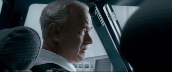 Movie still from “Sully” (2016), directed by Clint Eastwood – An older man looking out the window of an airplane; Close Up shot, Low angle