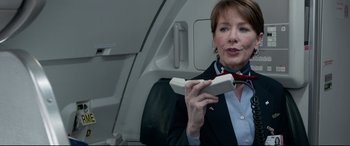 Movie still from “Sully” (2016), directed by Clint Eastwood – A woman holding a phone while sitting on a plane; Close Up shot, Low angle