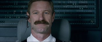 Movie still from “Sully” (2016), directed by Clint Eastwood – A person wearing a suit and tie; Close Up shot, Low angle