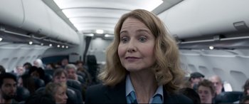 Movie still from “Sully” (2016), directed by Clint Eastwood – A woman in a business suit on an airplane; Close Up shot, Over the shoulder angle