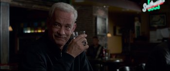 Movie still from “Sully” (2016), directed by Clint Eastwood – An older man holding a wine glass in his right hand; Close Up shot, Over the shoulder angle