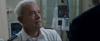 Movie still from “Sully” (2016), directed by Clint Eastwood – An older man wearing a white uniform looking up at the sky; Close Up shot, High angle