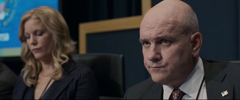 Movie still from “Sully” (2016), directed by Clint Eastwood – A man with a bald head sitting in front of another man; Close Up shot, Over the shoulder angle