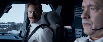 Movie still from “Sully” (2016), directed by Clint Eastwood – A man sitting in the back seat of a vehicle; Close Up shot, Low angle