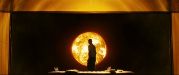 Movie still from “Sunshine” (2007), directed by Danny Boyle – A man standing in front of a large yellow sun; Extreme Wide shot, Low angle