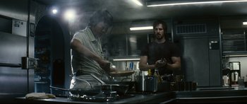Movie still from “Sunshine” (2007), directed by Danny Boyle – Two people in a kitchen preparing food in a restaurant; Medium shot, Low angle