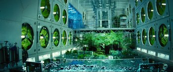 Movie still from “Sunshine” (2007), directed by Danny Boyle – A building that has plants growing inside of it; Extreme Wide shot, High angle