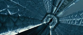 Movie still from “Sunshine” (2007), directed by Danny Boyle – A person is walking down a spiral staircase; Extreme Wide shot, Overhead angle