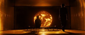 Movie still from “Sunshine” (2007), directed by Danny Boyle – A man sitting in front of an image of the sun; Extreme Wide shot, Over the shoulder angle