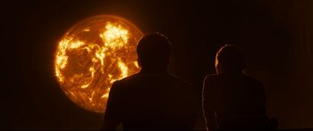 Movie still from “Sunshine” (2007), directed by Danny Boyle – Two people standing in front of the sun in the dark; Wide shot, Over the shoulder angle