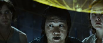 Movie still from “Sunshine” (2007), directed by Danny Boyle – A man with a black shirt under a yellow umbrella; Close Up shot, Low angle