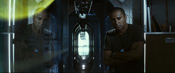 Movie still from “Sunshine” (2007), directed by Danny Boyle – A man standing next to a window in a room; Medium shot, Low angle