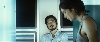 Movie still from “Sunshine” (2007), directed by Danny Boyle – A man and a woman sitting next to each other on a train; Medium shot, Over the shoulder angle