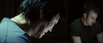 Movie still from “Sunshine” (2007), directed by Danny Boyle – A person's face with a dark background; Close Up shot, Over the shoulder angle
