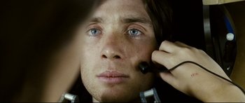 Movie still from “Sunshine” (2007), directed by Danny Boyle – A person using a brush on their face; Extreme Close Up shot, Overhead angle