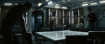 Movie still from “Sunshine” (2007), directed by Danny Boyle – A woman sitting at a table in front of a man; Wide shot, High angle