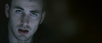 Movie still from “Sunshine” (2007), directed by Danny Boyle – A person's face with a dark background; Extreme Close Up shot, Low angle