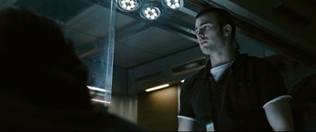 Movie still from “Sunshine” (2007), directed by Danny Boyle – A man standing in front of a window in a dark room; Close Up shot, Low angle