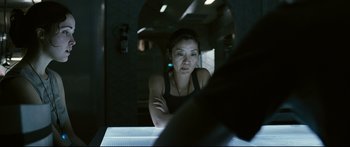 Movie still from “Sunshine” (2007), directed by Danny Boyle – A woman sitting at a table in a dark room; Close Up shot, Over the shoulder angle