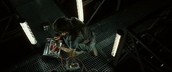 Movie still from “Sunshine” (2007), directed by Danny Boyle – A man standing in a room with a bunch of electronics; Medium shot, Overhead angle