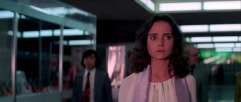 Movie still from “Suspiria” (1977), directed by Dario Argento – A woman standing in front of a man in a suit; Close Up shot, Low angle