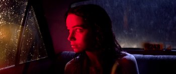 Movie still from “Suspiria” (1977), directed by Dario Argento – A woman is sitting in a dark room with red lighting; Close Up shot, Low angle