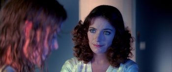 Movie still from “Suspiria” (1977), directed by Dario Argento – A young woman with blue eyes and brown curly hair; Close Up shot, Over the shoulder angle