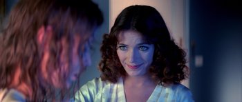 Movie still from “Suspiria” (1977), directed by Dario Argento – A young woman with blue eyes looking into a mirror; Close Up shot, Over the shoulder angle
